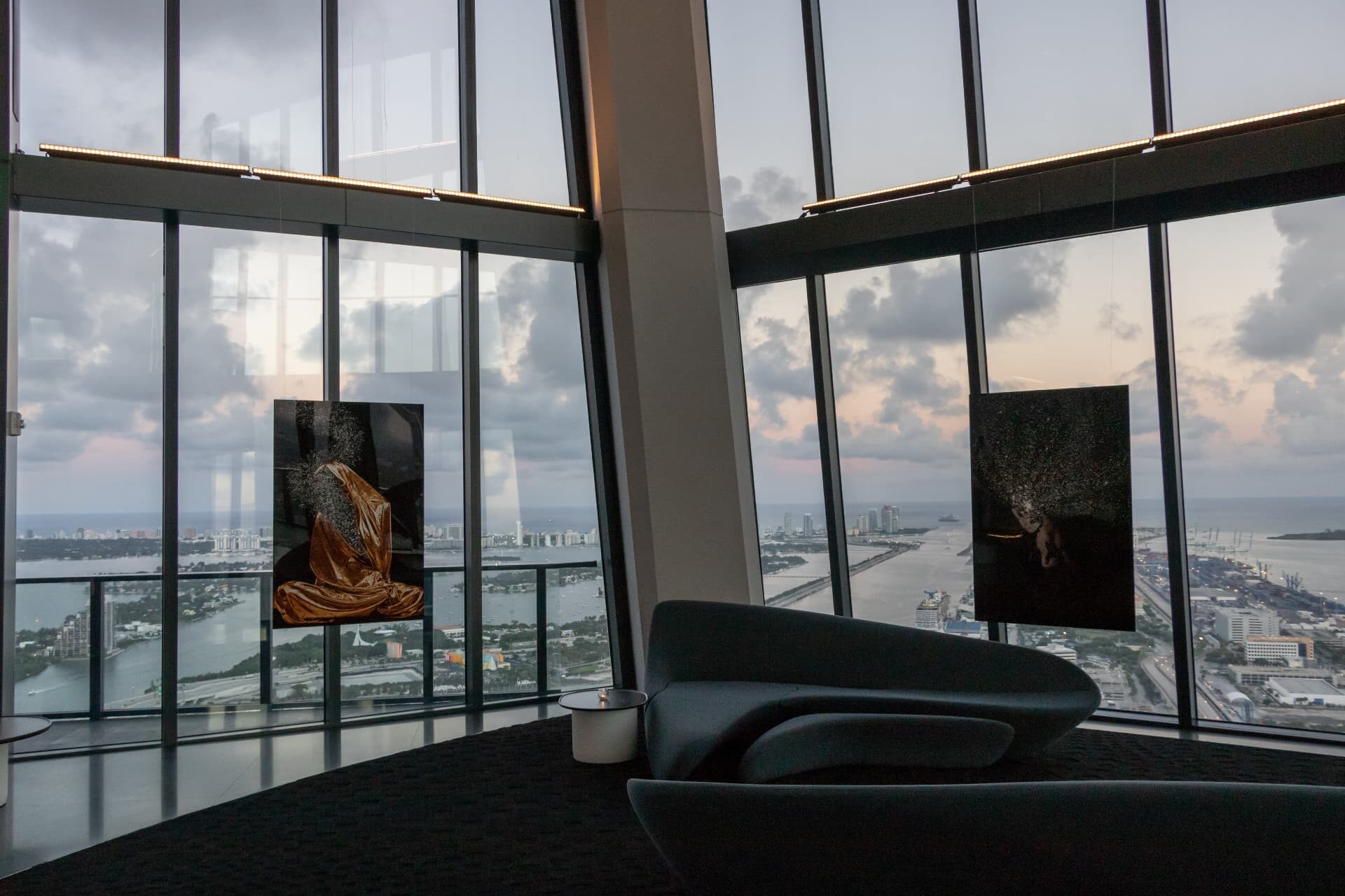 Suspended artworks framed by panoramic Miami bay views at dusk, 1000 Museum, Miami